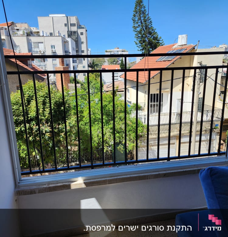 מעקה ברזל שחור במרפסת עם נוף עירוני